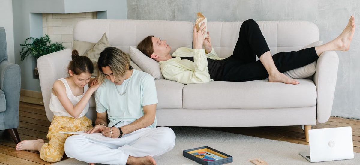 Father and daughter bonding in cozy living room with books and games, creating joyful family moments.